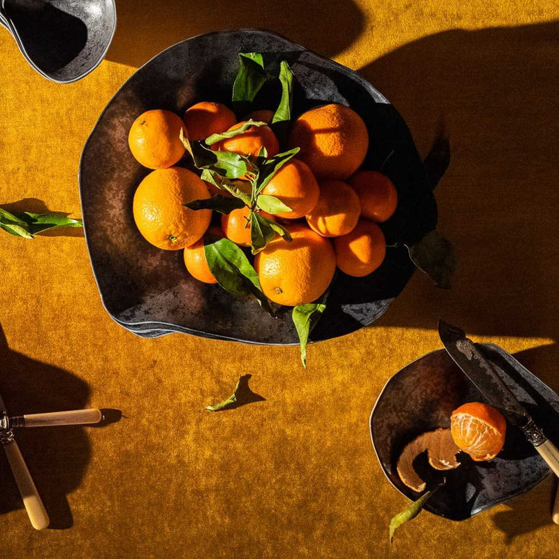 Luxury Limoges porcelain large dinner plates Graphite No6 Indulge Sarah-Linda with oranges on a wooden table with a knife and another bowl of oranges.