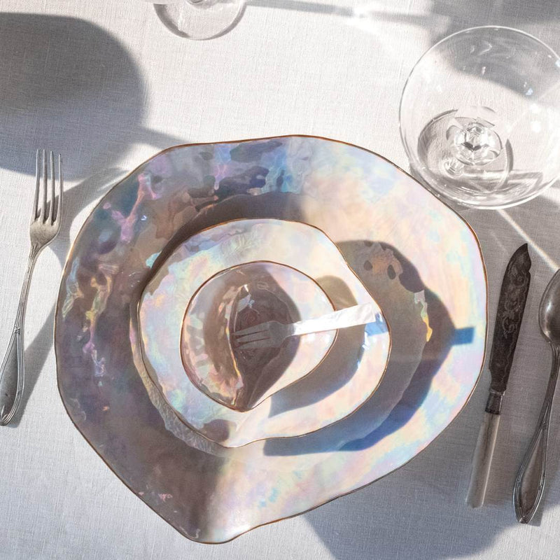 Shell-inspired porcelain large dinner plates Pearlescent finish No6 Indulge on a table with silverware and a glass.