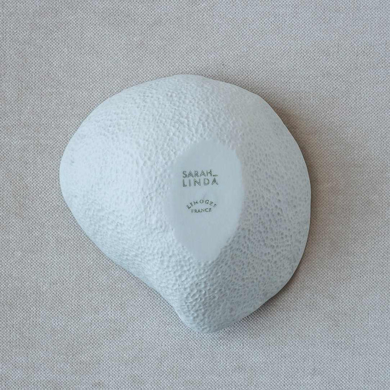 Light blue ceramic bowl with 'Sarah Linda' branding on a beige background