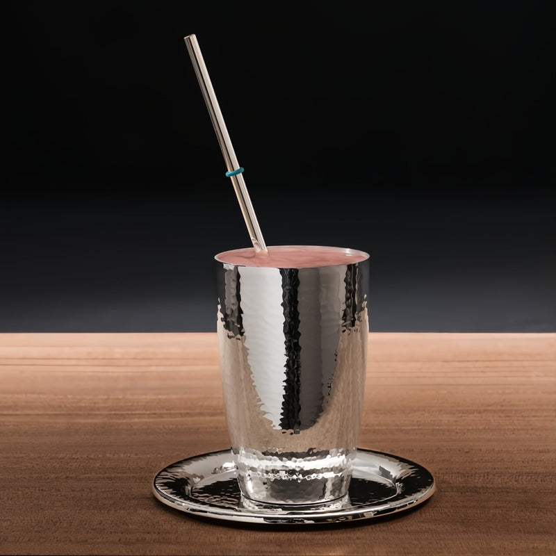 Styled drink with Silver-plated reusable drinking straw with cleaning brush and decorative rings by Robbe & Berking.