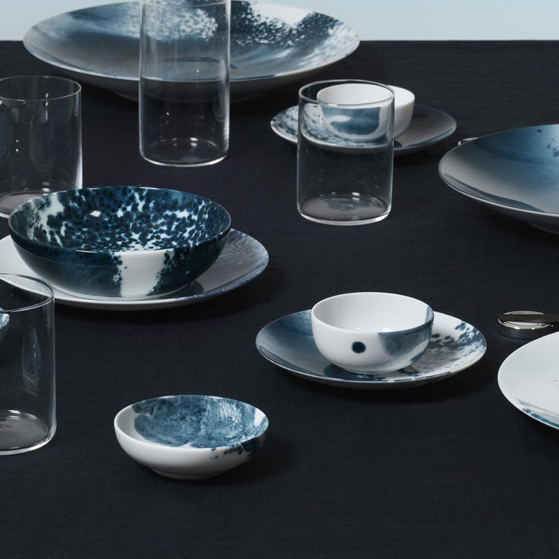 Marine-inspired porcelain bowl 8.5cm Abysses collection Raynaud on a black tablecloth with clear glasses.