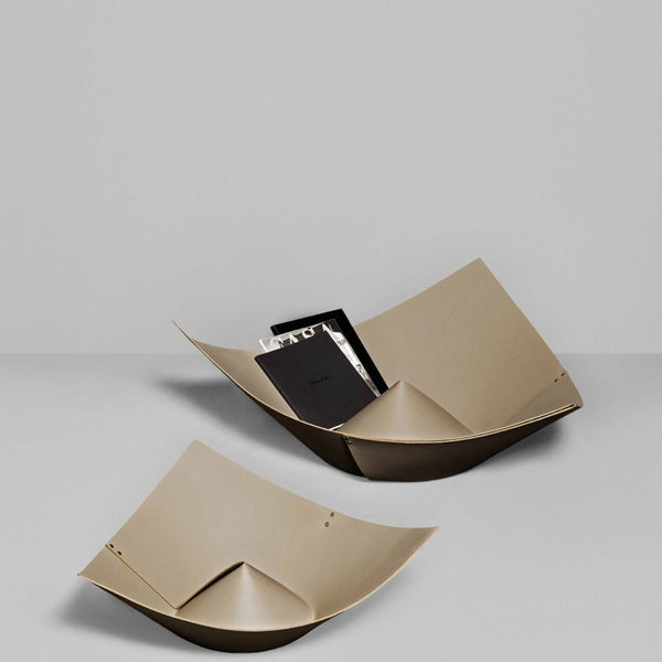 Beige decorative bowl with a black interior on a light gray background