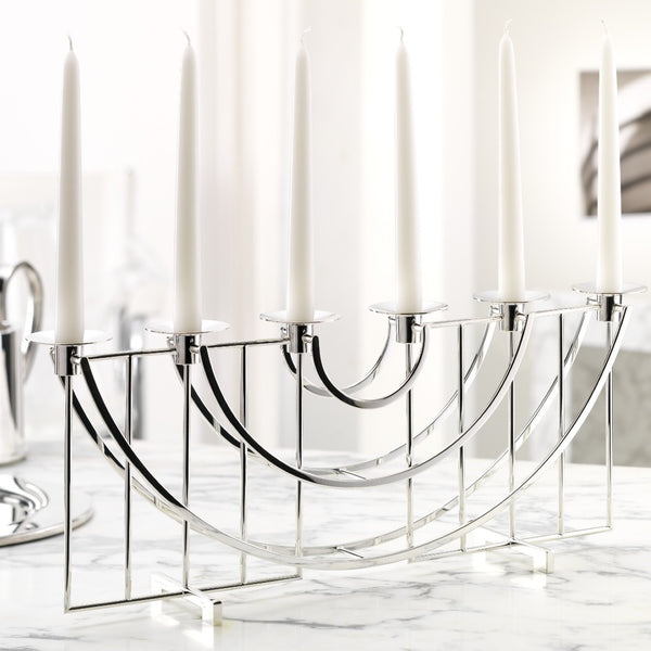 Silver candelabra with white candles on a marble surface