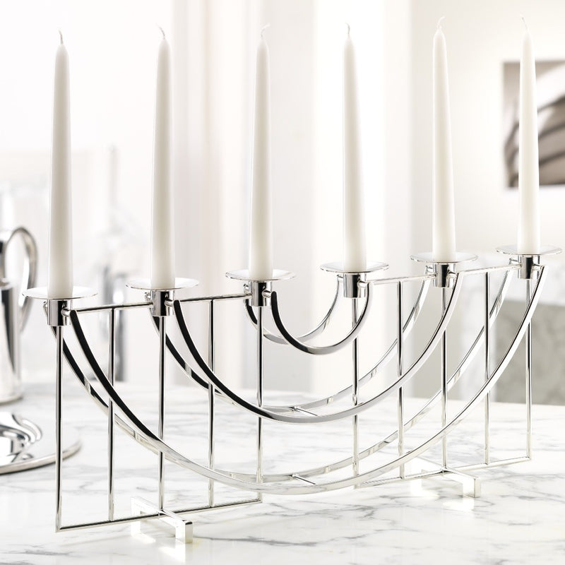 Silver candelabra with white candles on a marble surface