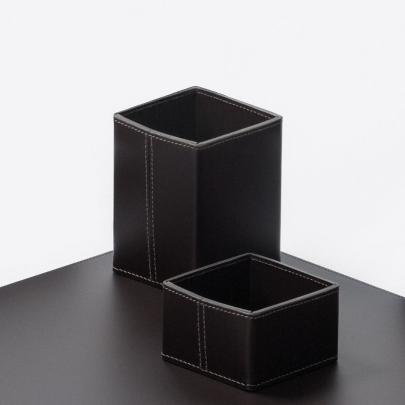Two black leather desk organizers on a dark surface with a white background