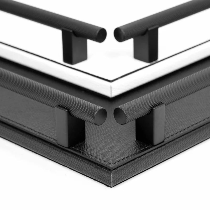 Close-up of a corner where two black metal bars meet on a white background