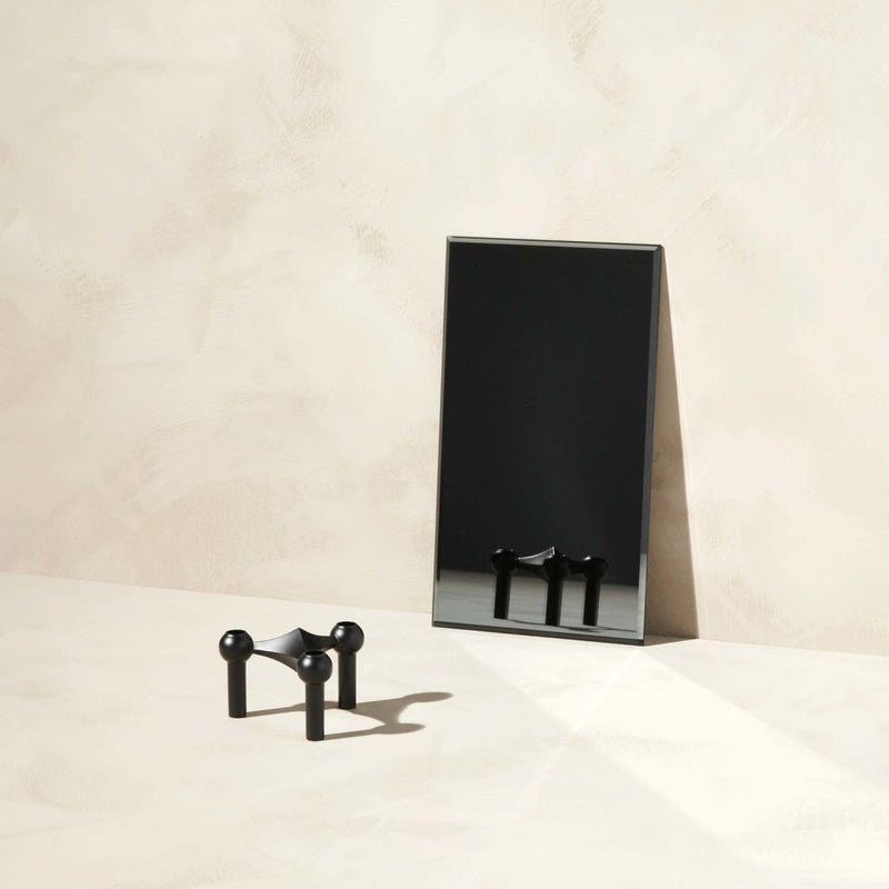 Black rectangular mirror with 1 piece black candle holder Stoff Nagel on a beige surface with a neutral background