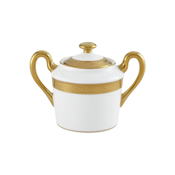 White sugar bowl with gold accents on a white background