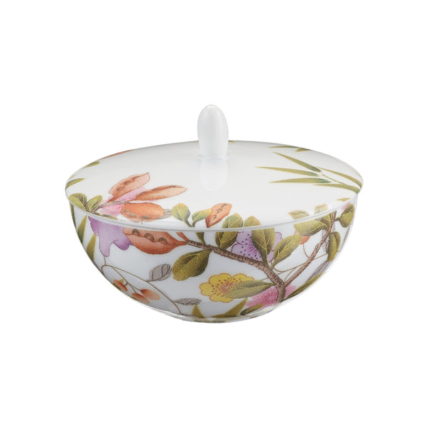 A white porcelain sugar bowl with floral and animal patterns, including birds and butterflies, from the Paradis collection by Raynaud.