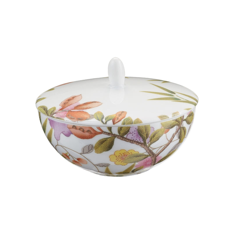A white porcelain sugar bowl with floral and animal patterns, including birds and butterflies, from the Paradis collection by Raynaud.