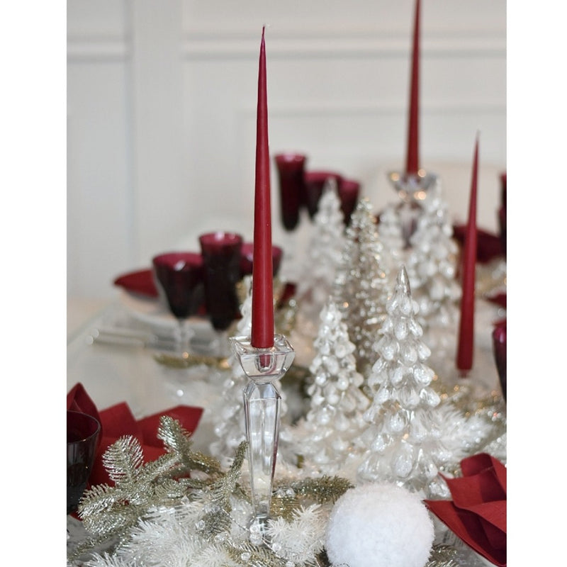 Decorative table setting with red candles, silver trees, and white decorations.