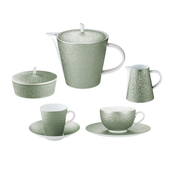 Green ceramic tea set with teapot, cups, and saucers on a white background