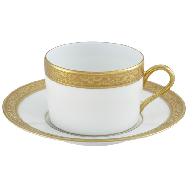 A white porcelain tea cup with gold Renaissance style border inlaid with fine gold details, accompanied by a saucer with a matching design.