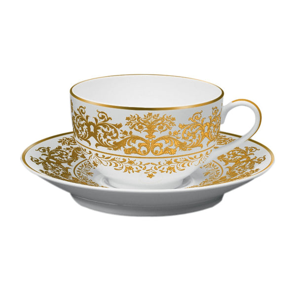 A white porcelain tea cup with gold floral patterns accompanied by a matching saucer.