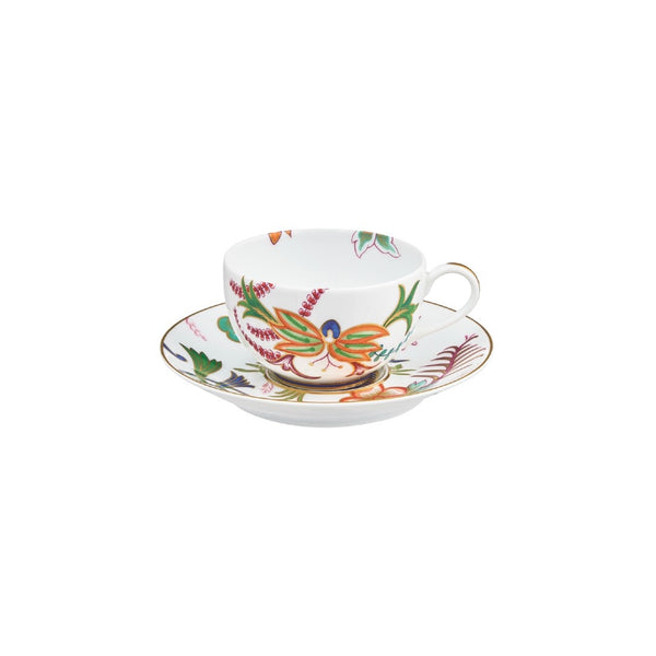 Teacup and saucer with colorful floral design on a white background