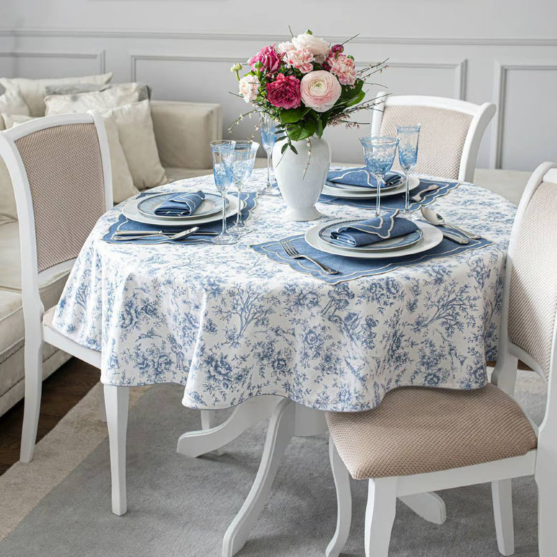 Dining table styled with white and blue tablecloth and white vase with flowers
