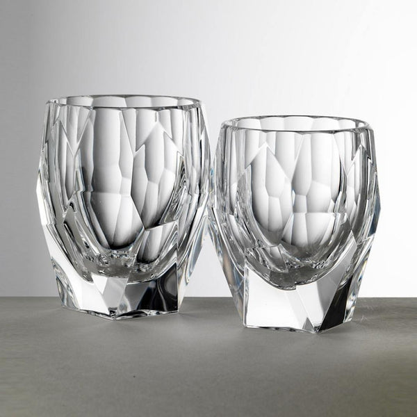 Two crystal glasses with textured design on a gray surface and background