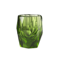 Green glass tumbler with textured surface on a white background