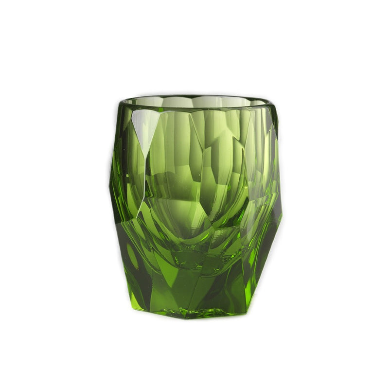 Green glass tumbler with textured surface on a white background