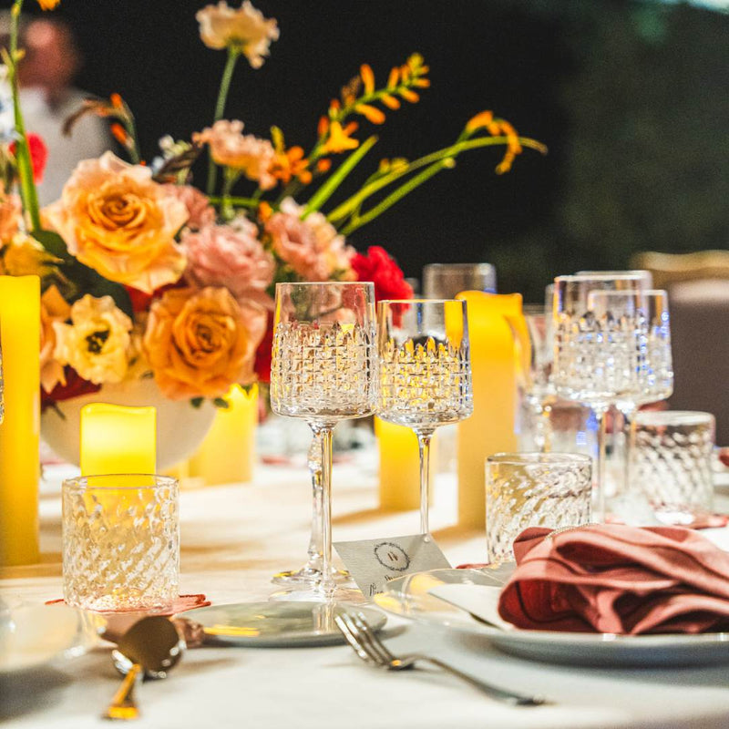 Decorative table setting with flowers, candles, and glassware Elegant Ulysse water glass by Cristallerie de Montbronn, modern crystal with mythological details.