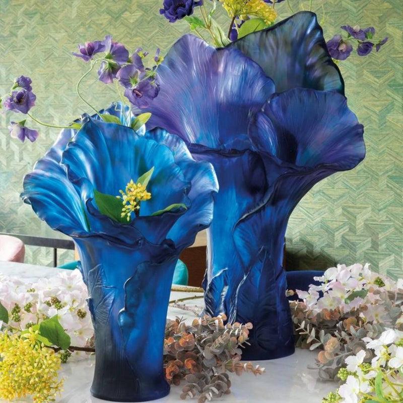 Two blue glass vases Arum by Daum with floral designs on a decorative background