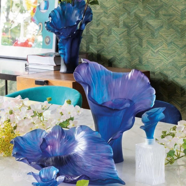 Blue glass sculptures on a table with a decorative background