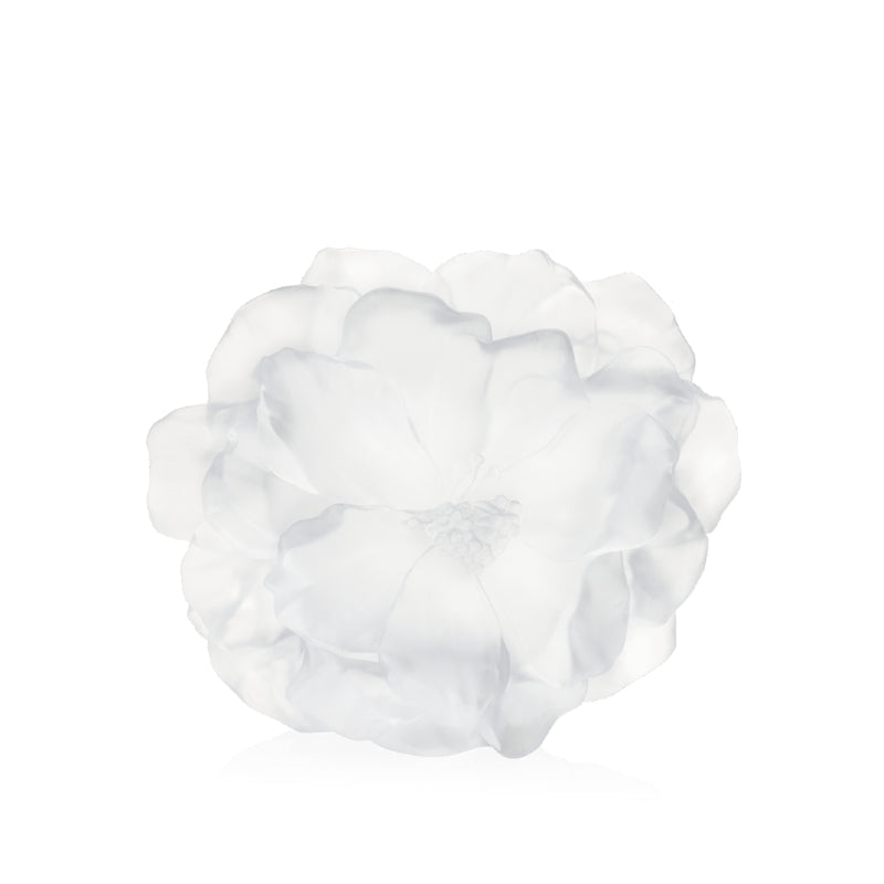 A white crystal vase with a floral design, resembling a camellia flower, on a plain background.