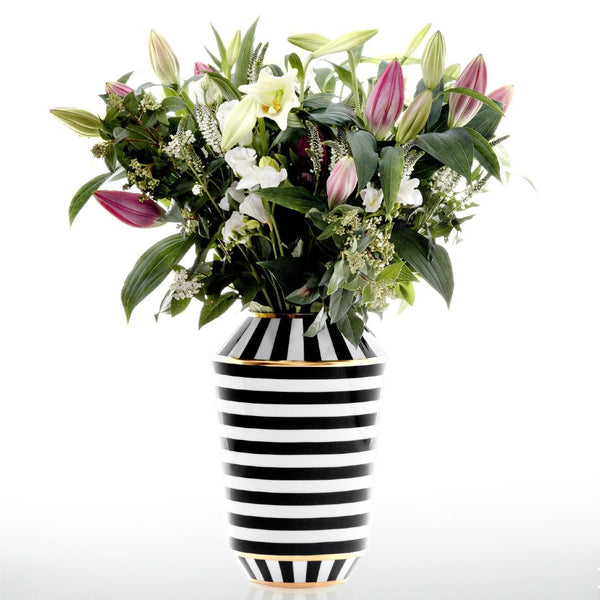 Black and white striped vase with a bouquet of flowers on a white background