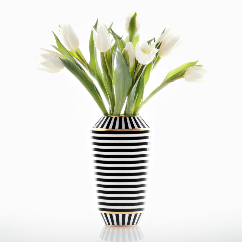 Black and white striped vase with white tulips on a white background