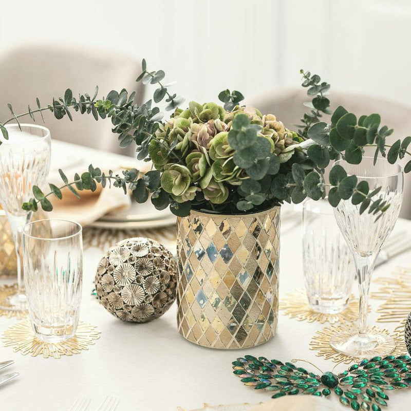 Decorative table setting with a vase of flowers and tableware.