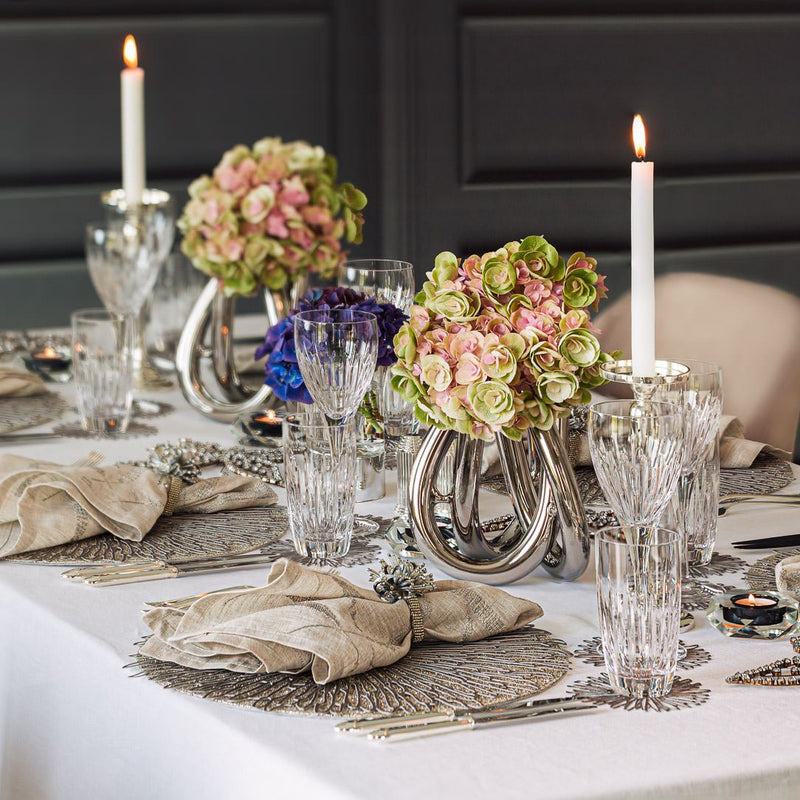 Elegant table setting with floral centerpieces, candles, and crystal glasses.