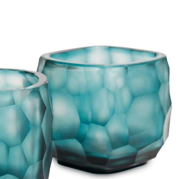 Two blue textured glass tealights on a white background