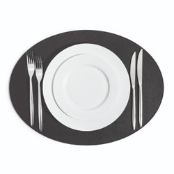 Black oval leather placemat with non-slip surface by Pinetti.