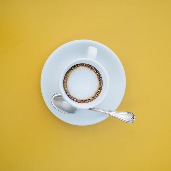 Palmette espresso spoon with Empire-inspired handle on coffee cup saucer.