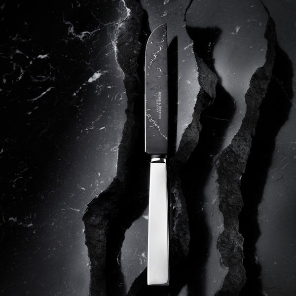 Robbe & Berking DLC-coated knife on marble table.
