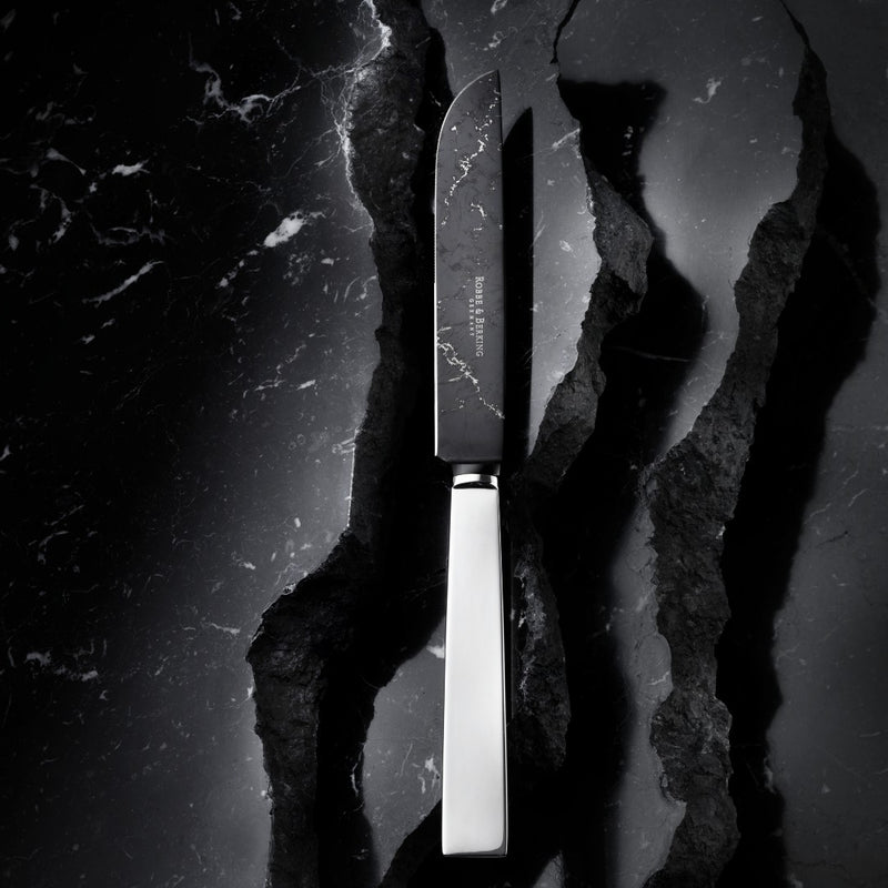 Robbe & Berking DLC-coated knife on marble table.