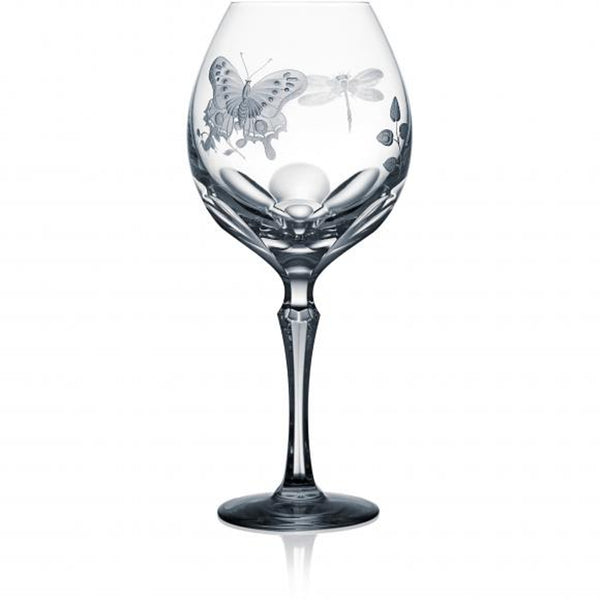 A clear red wine glass from Springtime collection with hand-engraved floral and insect motifs on the side.