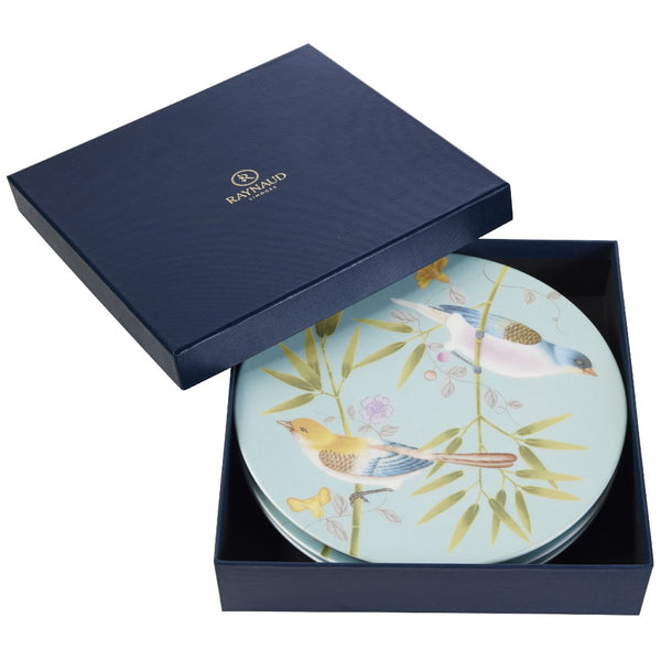A set of four turquoise-colored porcelain dessert plates with floral and bird motifs, presented in a navy blue gift box.