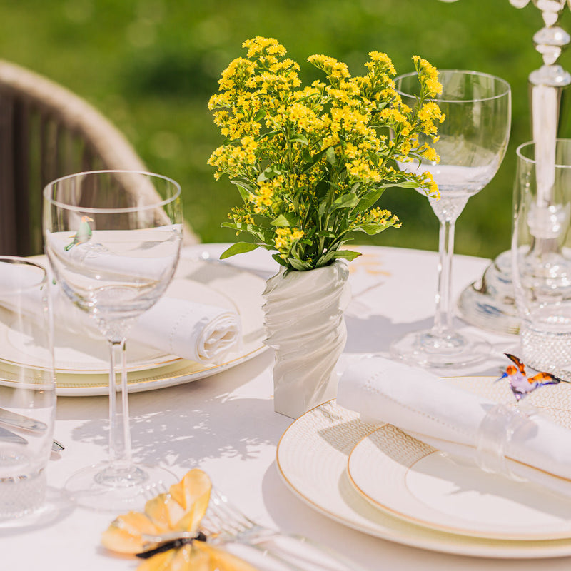 a table set with glasses and flowers