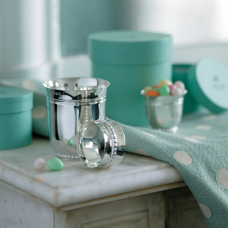 Silver-plated Perles napkin ring by Ercuis, styled next to a baby cup.