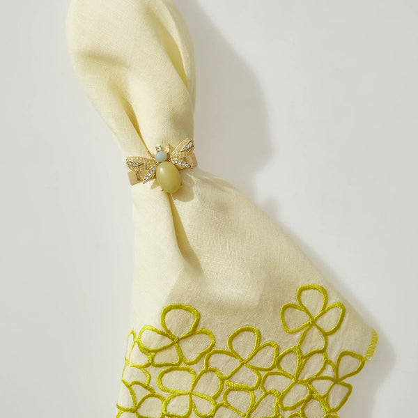 Hydrangea linen napkin styled with gold bee motif napkin ring, top view, sold by Amiramour