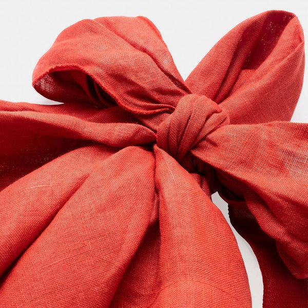 Close-up of bow on pre-tied red linen napkin in a bow shape by Joanna Buchanan 