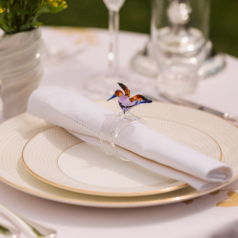 White linen napkin from the Florence collection styled with sglass bird napkin ring