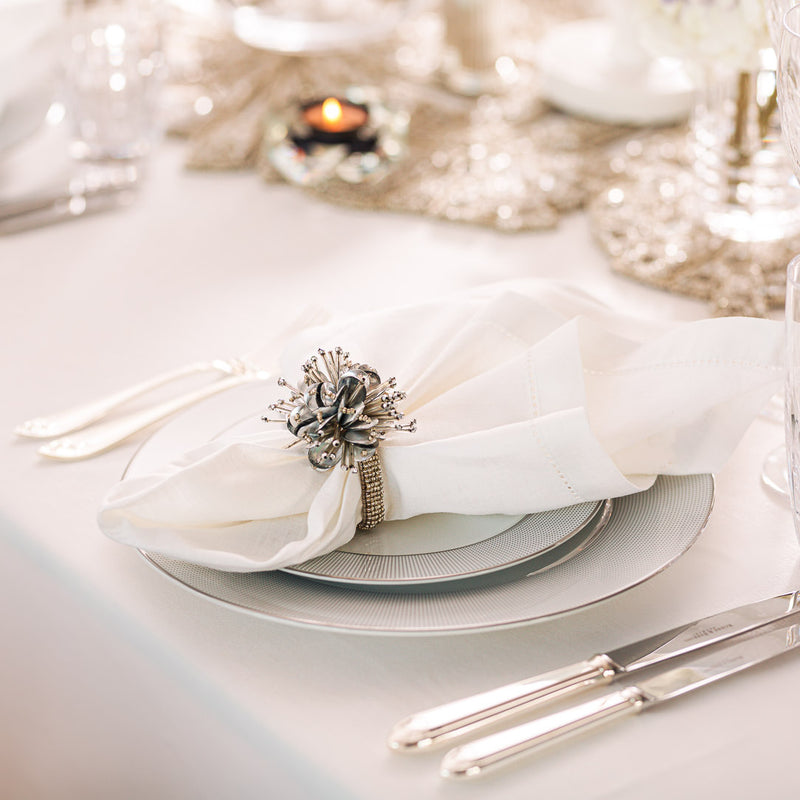 White linen napkin from the Florence collection styled with silver napkin ring