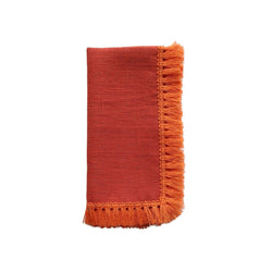Orange linen napkin with fringe folded on white background, sold at Amiramour.