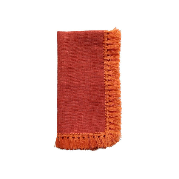 Orange linen napkin with fringe folded on white background, sold at Amiramour.