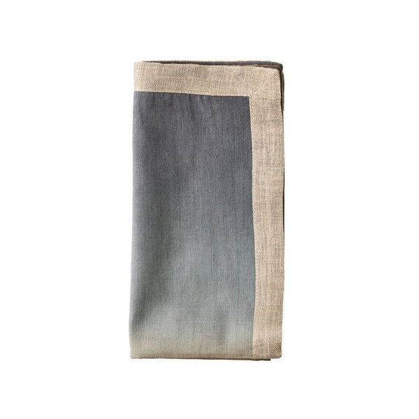 Beige, taupe, and grey linen napkin with metallic foil detail folded on white background.