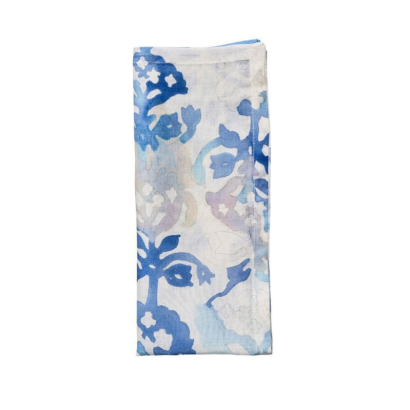 Watercolour linen napkin in white with blue, pink, and purple floral design folded on white background, sold at Amiramour.
