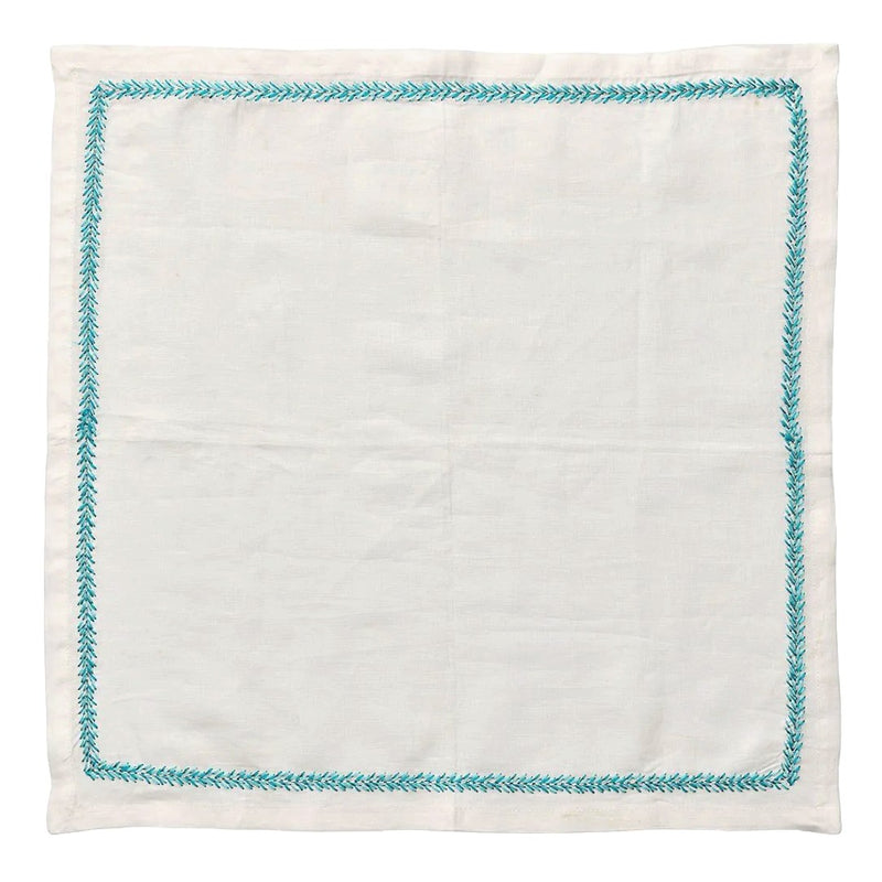 Unfolded linen napkin with turquoise embroidery by Kim Seybert, shown at Amiramour