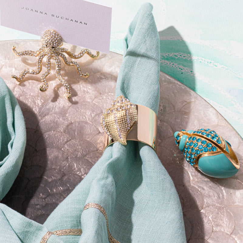 Turquoise napkin styled with Shell Napkin Ring and coordinating marine-themed decor